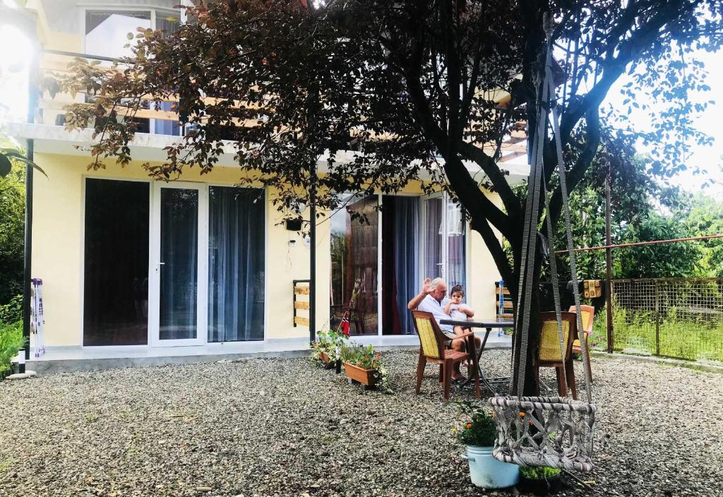 due persone sedute a un tavolo fuori da una casa di Dito House a Kobuleti