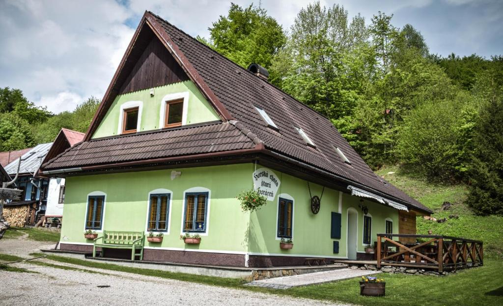 a green house with a brown roof at Horská chata Stará Horáreň 1 in Dobšiná