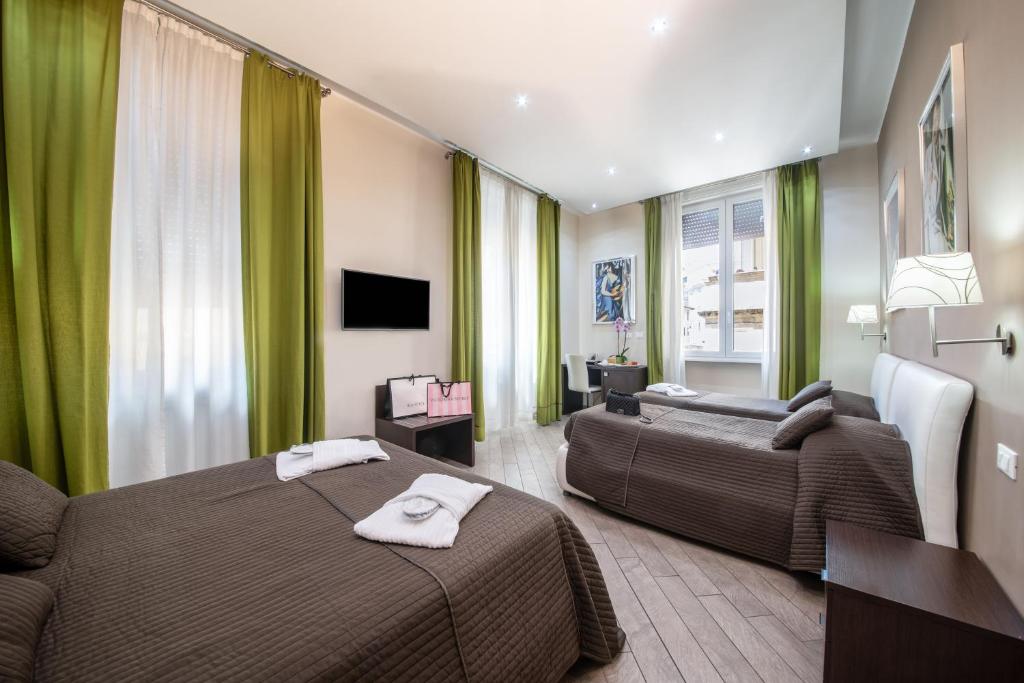 um quarto de hotel com duas camas e um sofá em Mia Resort em Roma