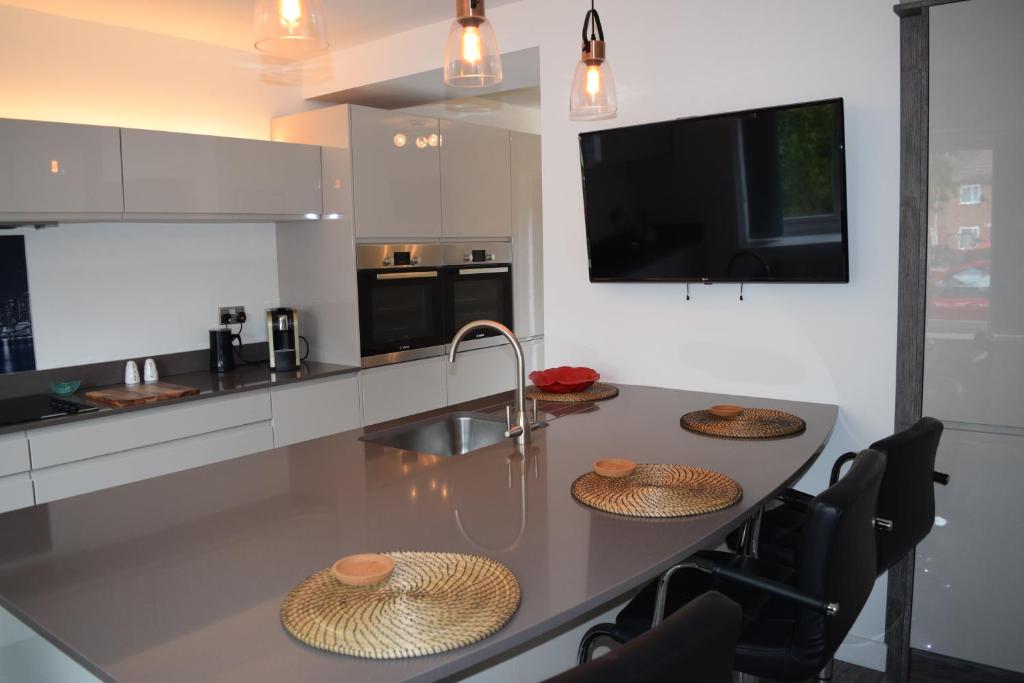 a kitchen with a table with three straw hats on it at Airport Stopzzz in Wythenshawe