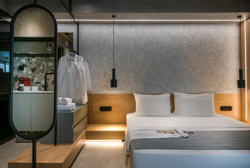 een hotelkamer met een bed en een spiegel bij King's Blue, Urban Suites in Heraklion