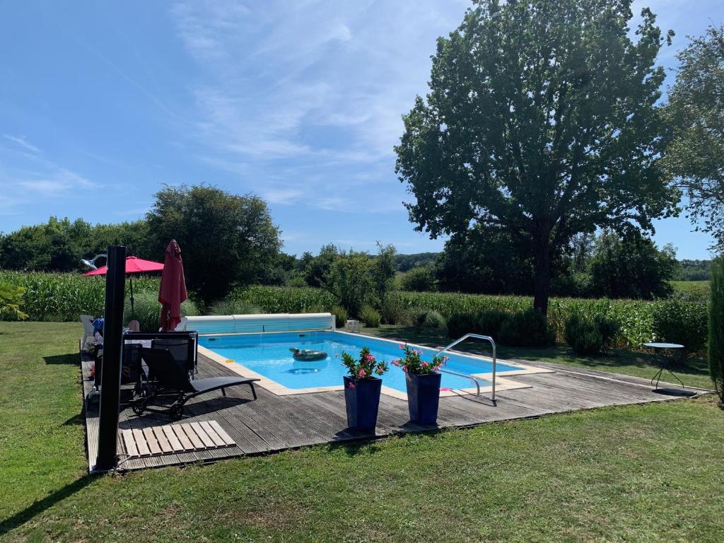 een zwembad in een tuin met een tafel bij Lovely gites with private pool, privacy & spacious garden in Saint-Étienne-de-Villeréal