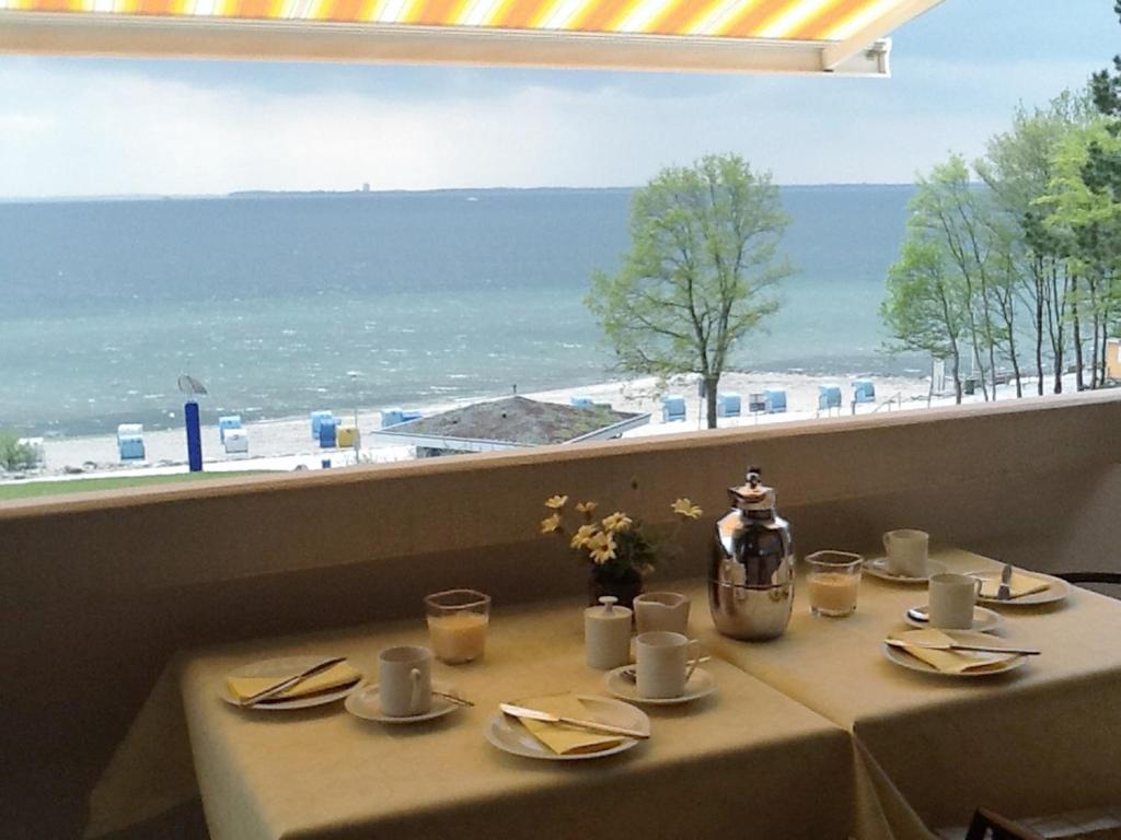 a table with a view of the beach from a window at Ferienpark Sierksdorf Nautilus Panorama-Meerblick in Sierksdorf