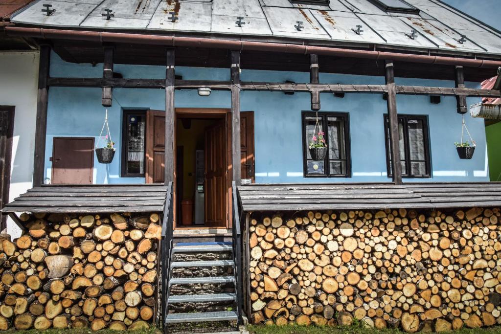 a blue house with a pile of logs at Stara Horaren 2 in Dobšiná