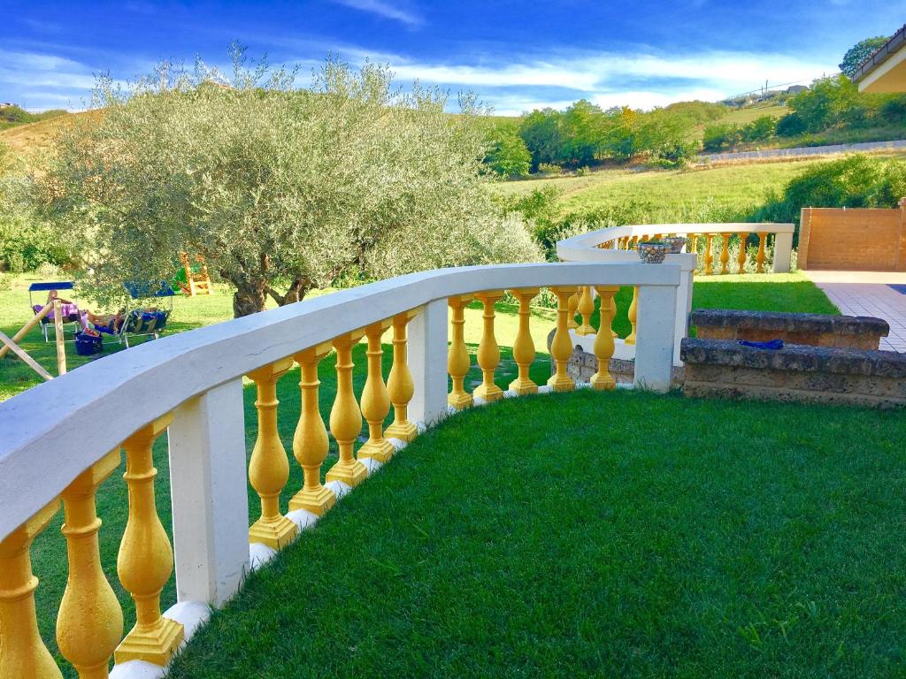 Silvi PaeseにあるChalet negli uliviの黄色の花瓶が草の上に飾られた白い柵