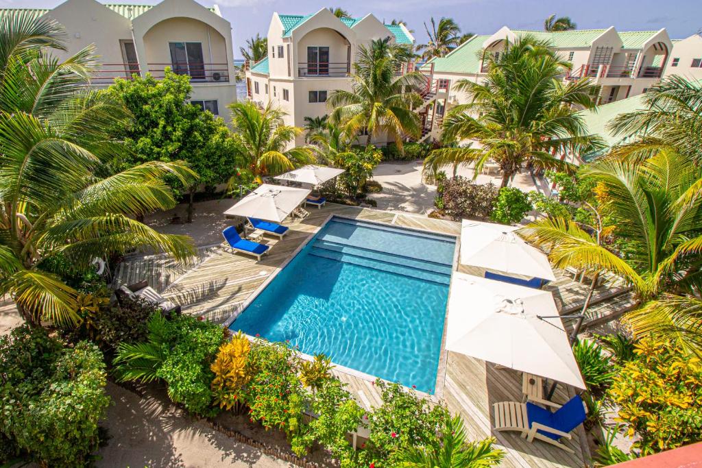 an aerial view of a resort pool with umbrellas and palm trees at Tres Cocos Resort in San Pedro