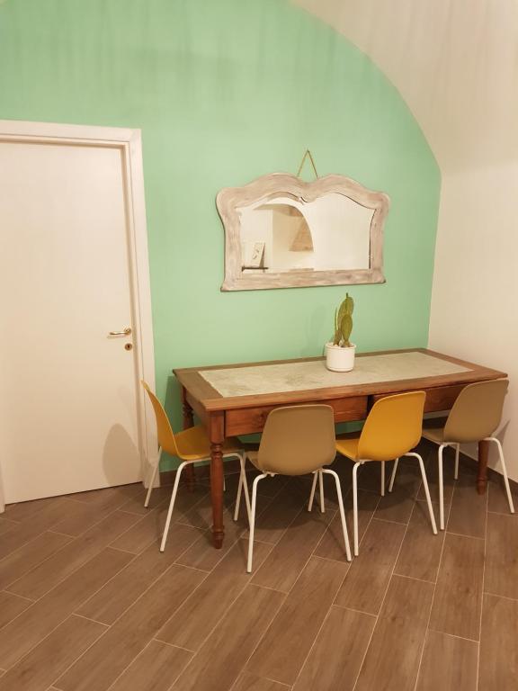 a dining room table with chairs and a mirror on the wall at Casa Arco della Chicca in Monopoli