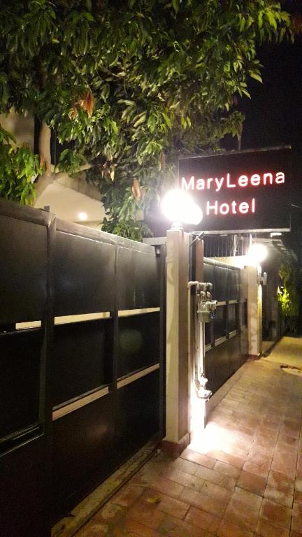 - une entrée à un hôtel la nuit avec un panneau dans l'établissement MaryLeena Hotel Gulberg, à Lahore