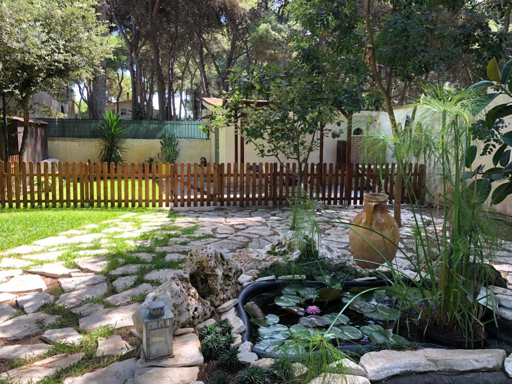 a garden with a pond and a wooden fence at Bungalow Fatamorgana in Pulsano