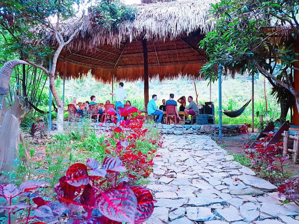 a group of people sitting under a pavilion at Du Gìa - Mường Trà Garden Homestay in Làng Cac