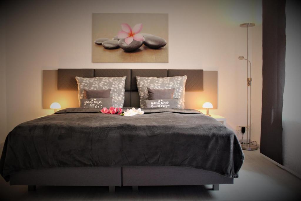 a bedroom with a large bed with flowers on it at BUDGET APARTMENTS - SALZHAUSBLICK FERIENWOHNUNGEN - TOP INNENSTADT LAGE am SALZHAUS STADTZENTRUM mit HOTELBETTEN in Zittau