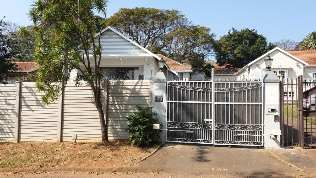 a white fence with a gate in front of a house at 100 on Girvan in Durban