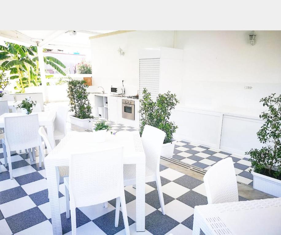 a dining room with a white table and white chairs at Casa Lu Salentu in Torre Lapillo