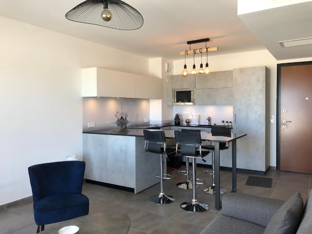 une cuisine avec une table et des chaises dans une pièce dans l'établissement T2 climatisé à Porticcio, 100m de la plage wifi fibre, à Porticcio