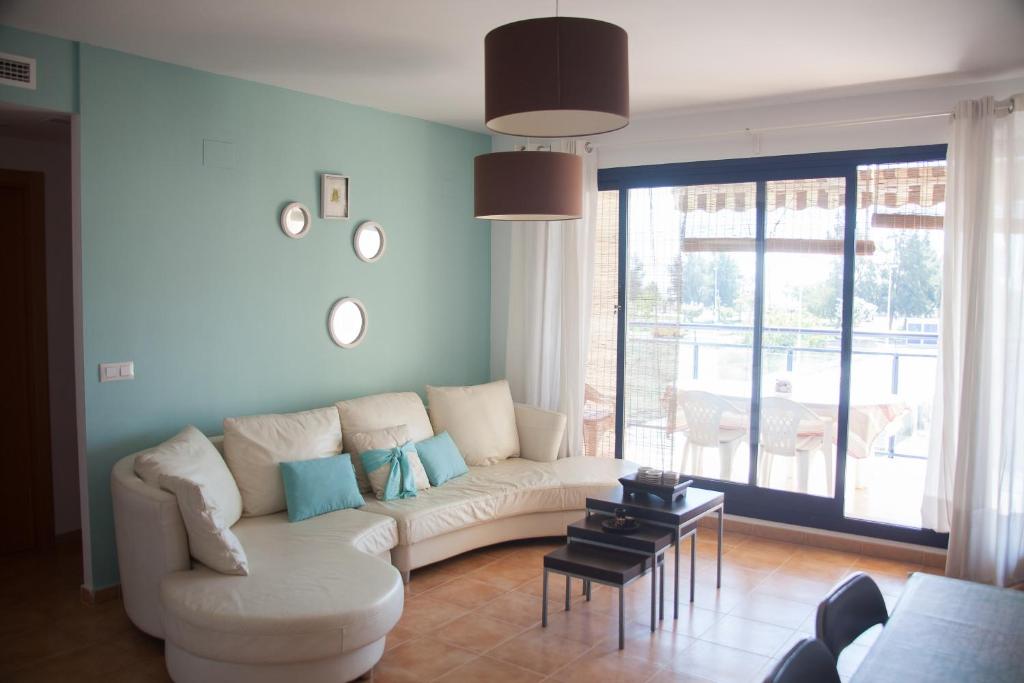 ein Wohnzimmer mit einem weißen Sofa und einem Tisch in der Unterkunft Apartamento Playa Moncofar - Xilxes in Moncófa
