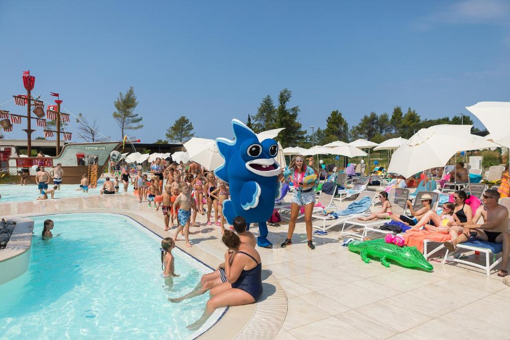 a group of people in a pool at a resort at Mobile Homes Camping Santa Marina, Lanterna in Poreč