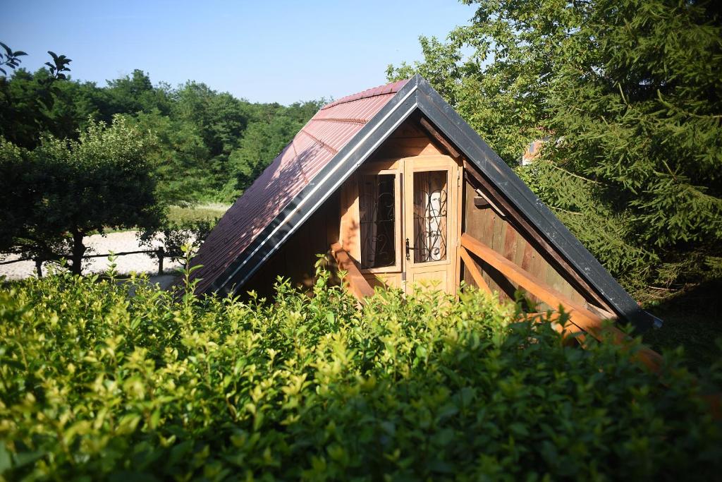 a small house with a tin roof on top of some bushes at Robinson Horseville in Karlovac