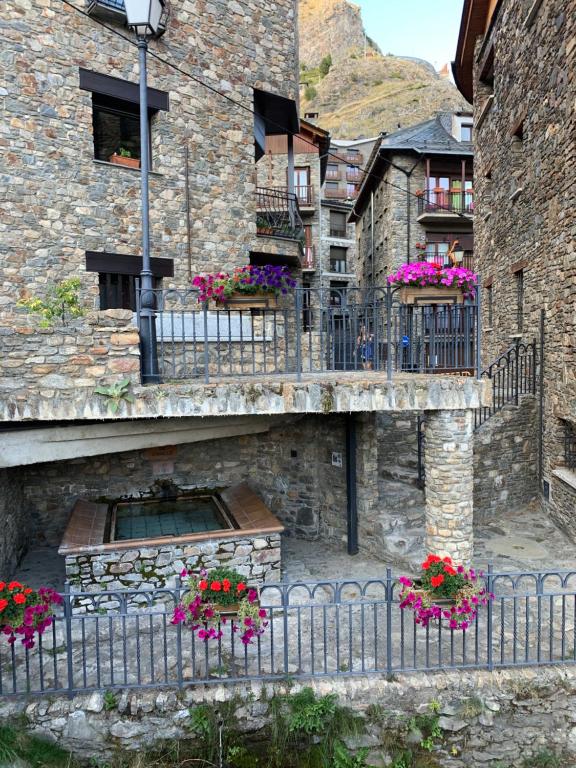 a stone building with flower boxes on a balcony at PASSAMANÉ 19 - Canillo - Casco Antiguo in Canillo