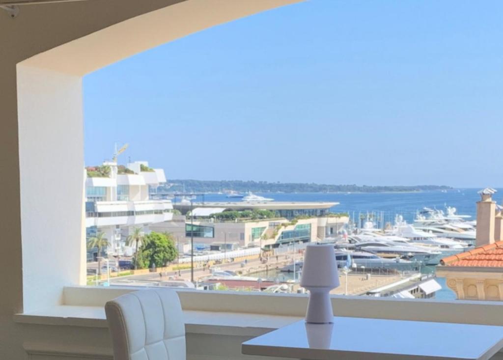 een eetkamer met uitzicht op een jachthaven bij La Goelette - Palais des Festivals in Cannes