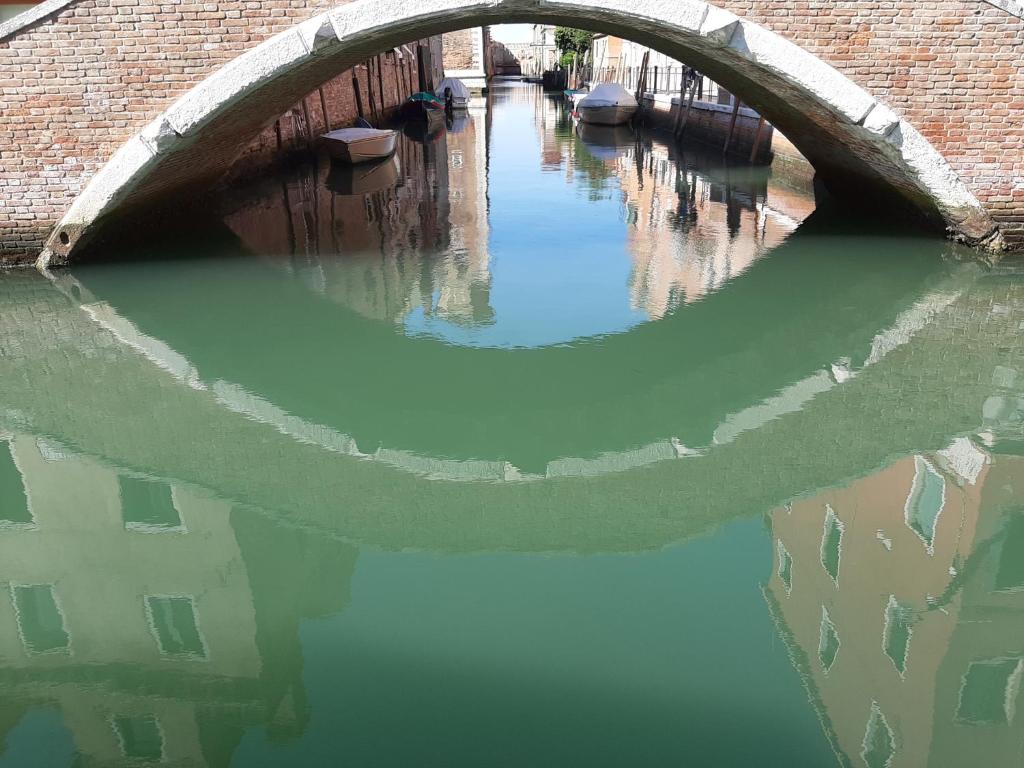 un puente de ladrillo sobre un canal con barcos en el agua en ISEPO APARTMENT, en Venecia