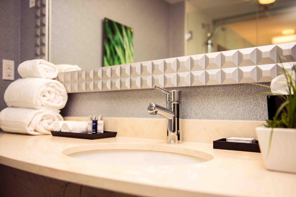 a bathroom counter with a sink and a mirror at Hotel BLU in Vancouver