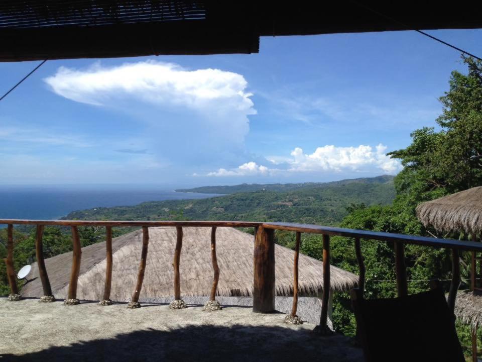 a balcony with a view of the ocean at Hillside Village apartment 72sqm size with kitchen in Siquijor