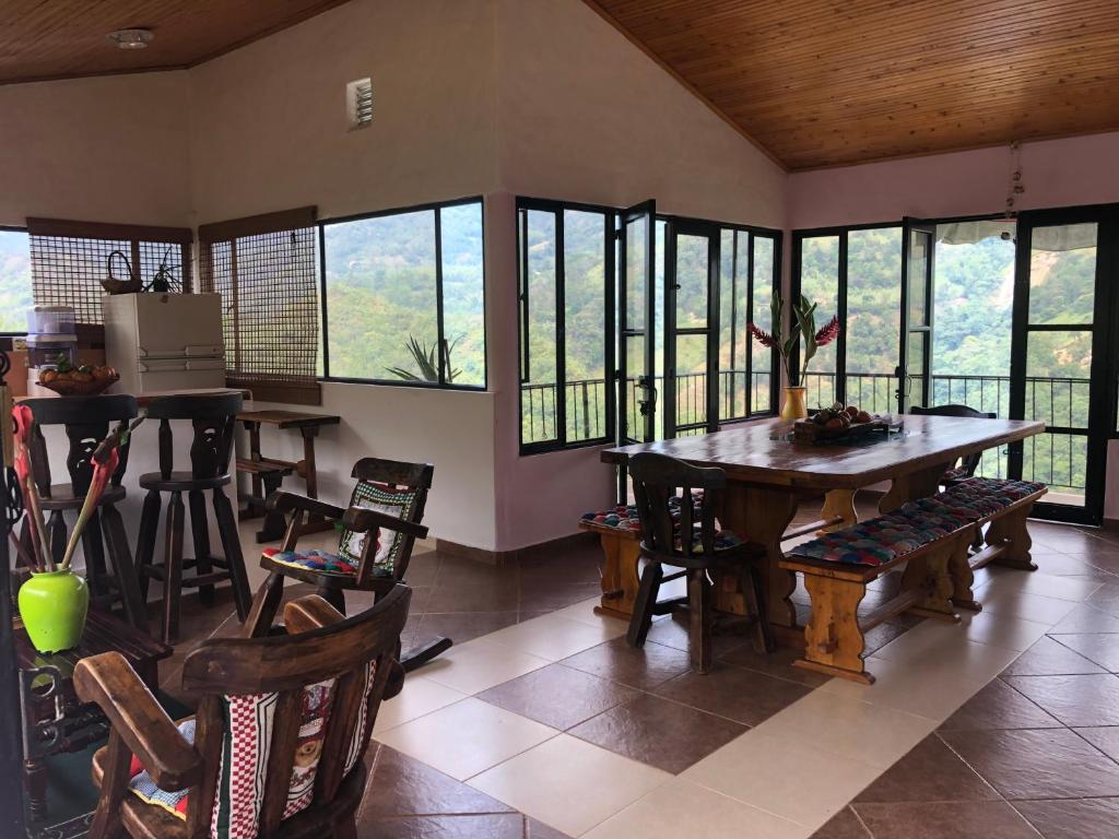 a dining room with a table and chairs and windows at finca Las Margaritas in La Vega