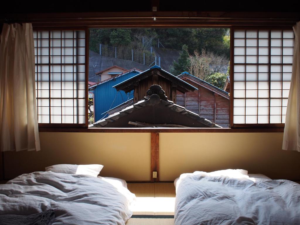 two beds in a room with a window at NORA in Numazu