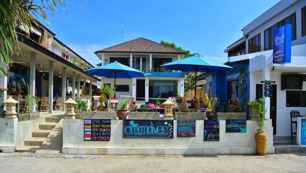 a restaurant with blue umbrellas in front of a building at Dream Divers Resort in Gili Trawangan