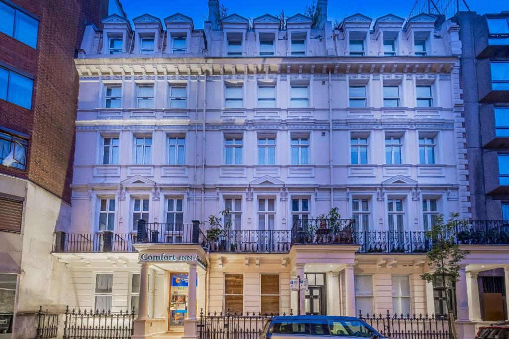 a white building with a car parked in front of it at Comfort Inn Hyde Park in London