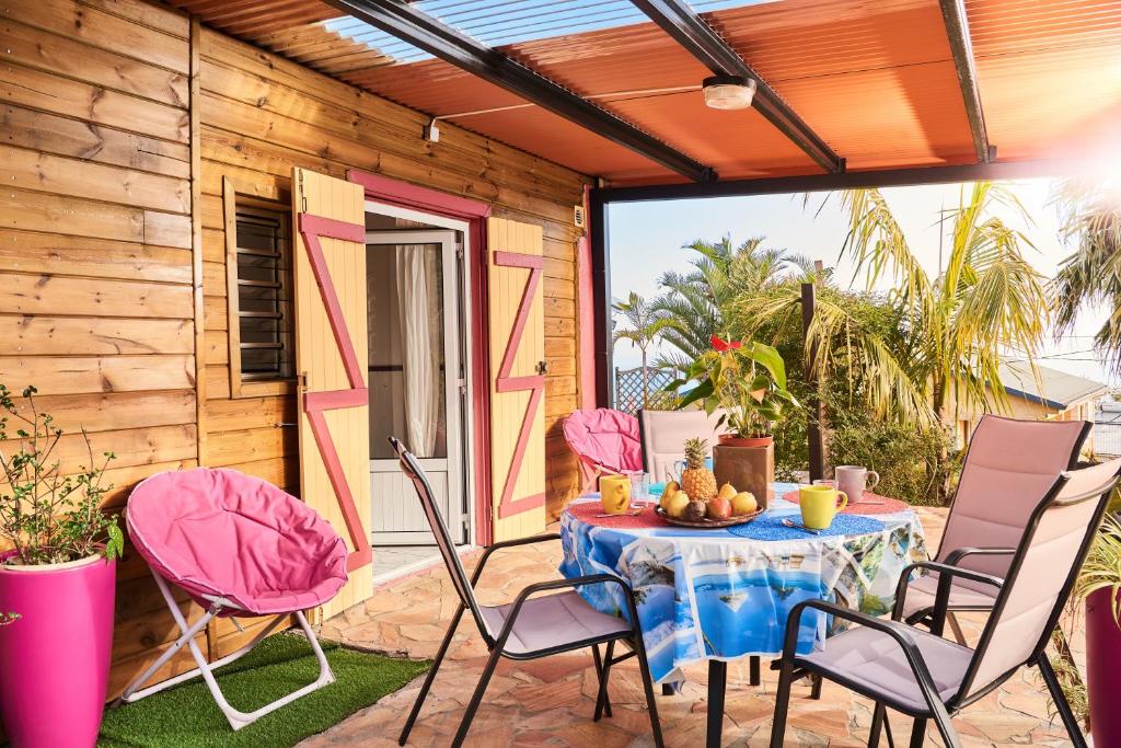 un patio con mesa y sillas en un porche en Le Bambou - 2 étoiles - Les Avirons, en Les Avirons