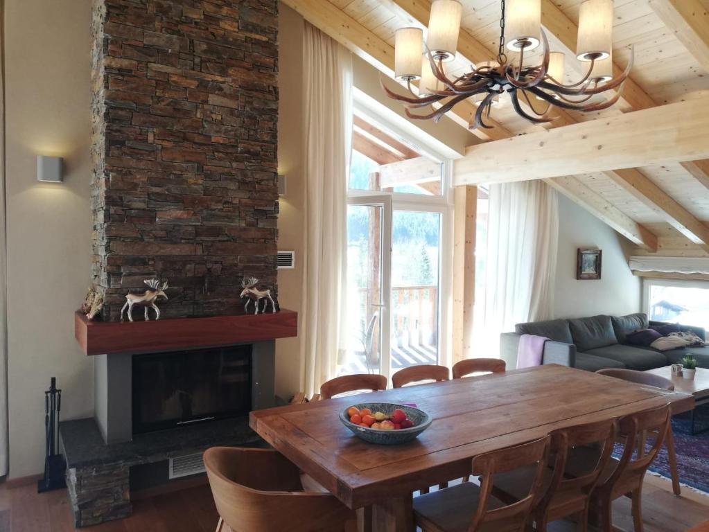 a living room with a wooden table and a fireplace at Pure Hinterthal in Maria Alm am Steinernen Meer