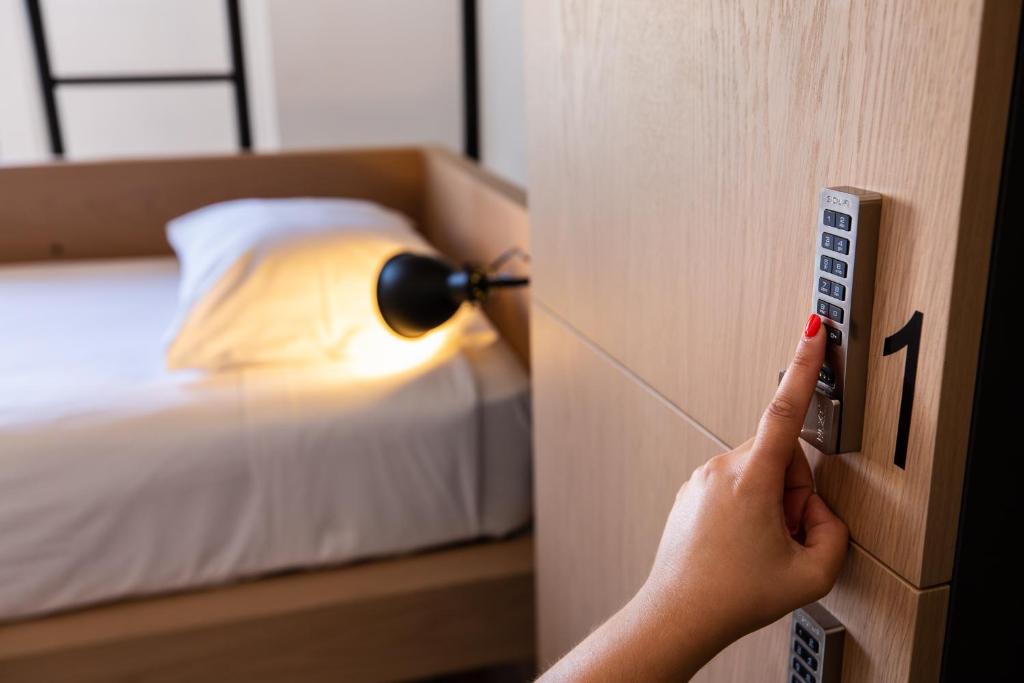 a person opening a door to a bedroom with a bed at Gallery Hostel in Porto
