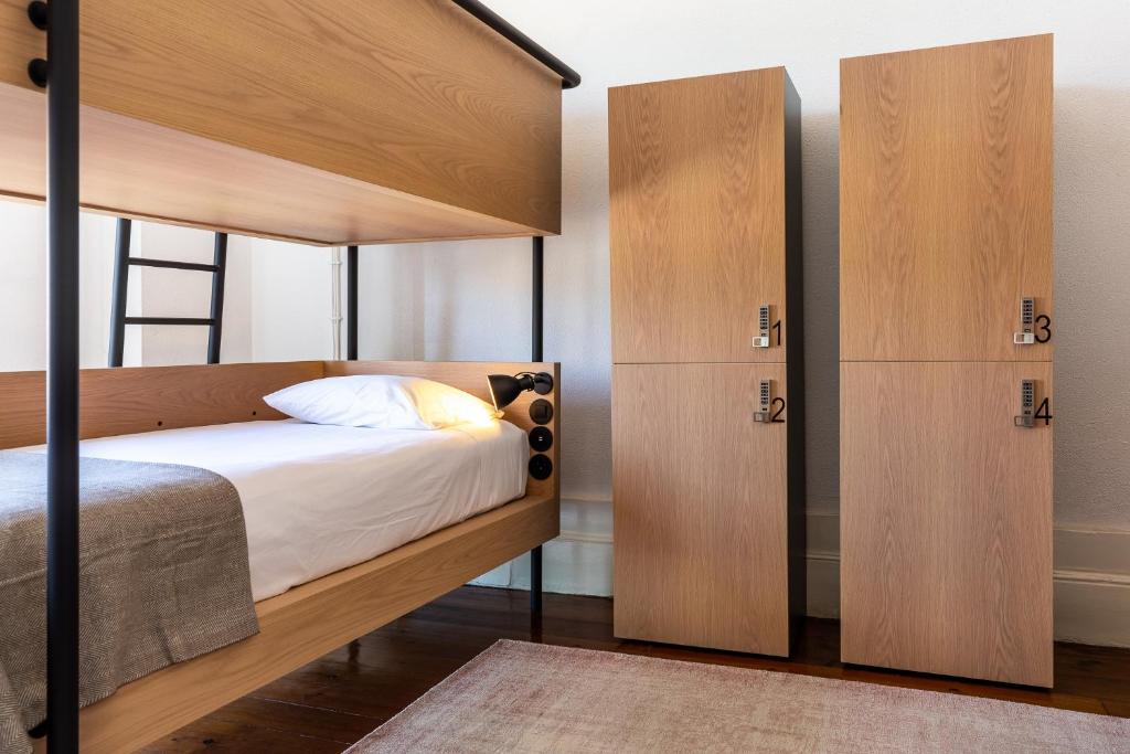 a bedroom with a bunk bed with wooden doors at Gallery Hostel in Porto