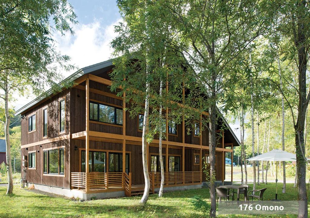 una gran casa de madera en medio de árboles en Country Resort Niseko en Niseko