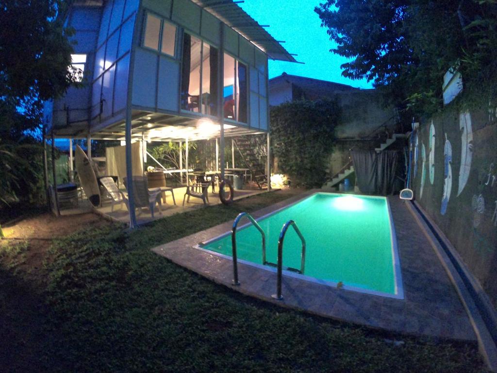 a swimming pool in front of a house at night at Anne's Maisonnette in Galle