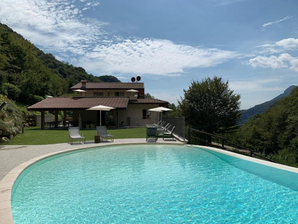 a swimming pool in front of a house at Piccola Valle in Vobarno