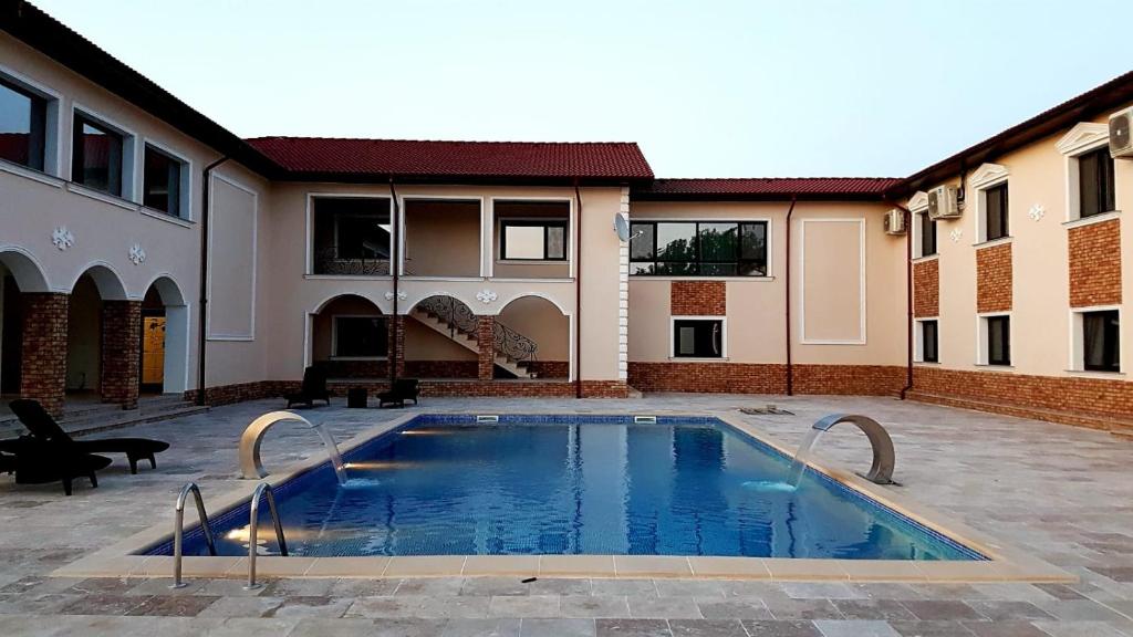 a swimming pool in the courtyard of a house at Domeniile Panciu Winery & Resort in Sîrbi