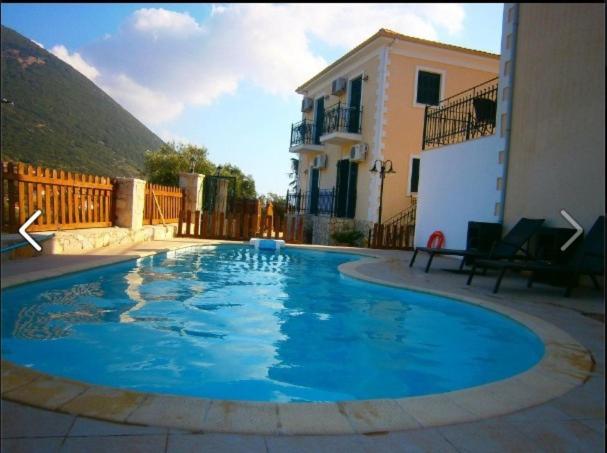 a large blue swimming pool in front of a house at Iriana Village Inn in Stavros