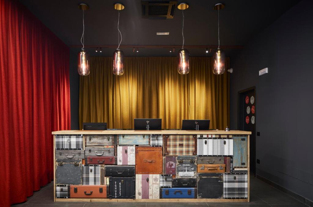 um quarto com uma mesa com malas em frente a um palco em The Modernist Hotel em Trieste