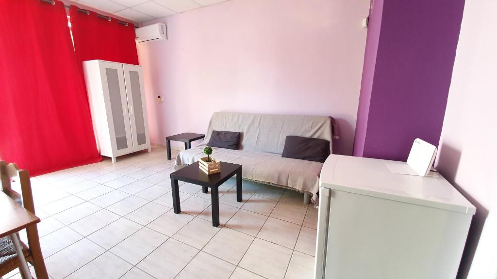 a small room with a bed and a table at TK-George Apartments by the Airport in Markopoulo