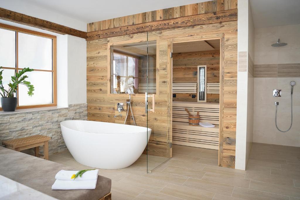 ein Badezimmer mit einer großen Badewanne und einer Dusche in der Unterkunft Ferienhaus Almruhe in Schwanberg