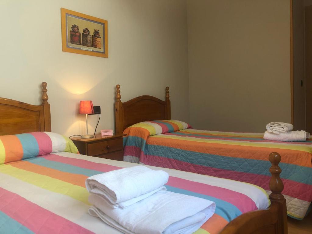 ein Zimmer mit 3 Betten und Handtüchern darauf in der Unterkunft Casa Dori in San Cristóbal de la Cuesta