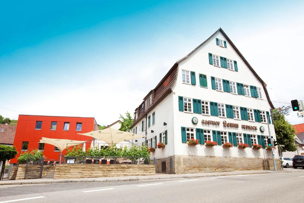 a white building with green shuttered windows on a street at Hotel Restaurant Lamm Hebsack in Remshalden