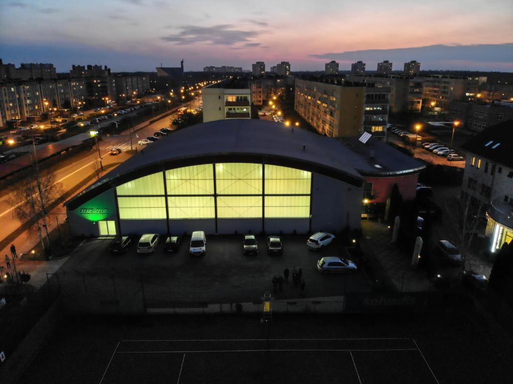 a large building with cars parked in a parking lot at Tenis Club in Kędzierzyn-Koźle