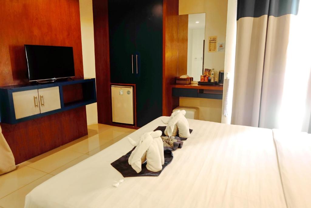 Postel nebo postele na pokoji v ubytování Calypso Patong Hotel