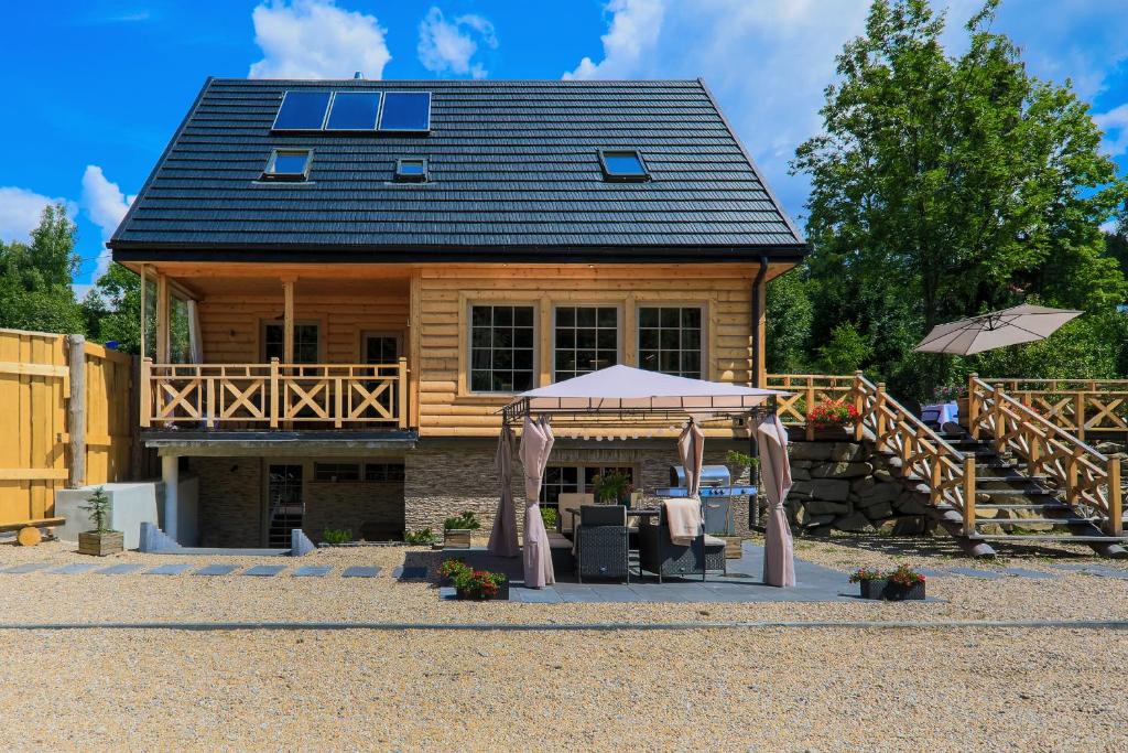 a log cabin with a tent in front of it at Domek nad Potokiem in Nowy Targ