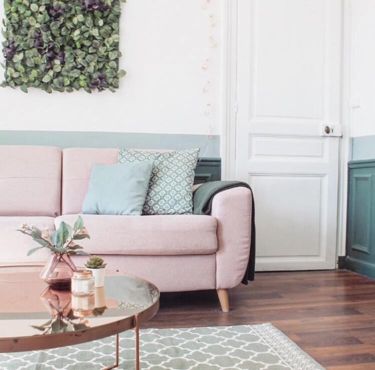 a living room with a pink couch and a table at Le classique champenois, centre ville, proche cathédrale in Reims