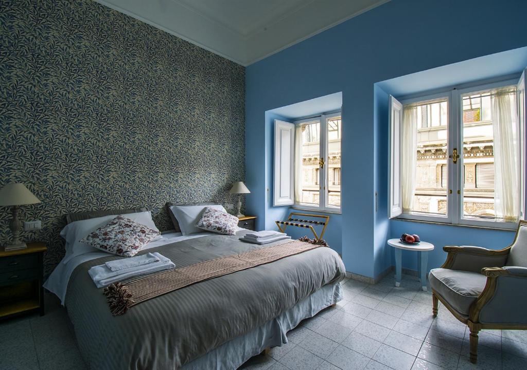 ein blaues Schlafzimmer mit einem Bett und einem Stuhl in der Unterkunft Domus Sibyllina, Galleria Umberto I in Neapel