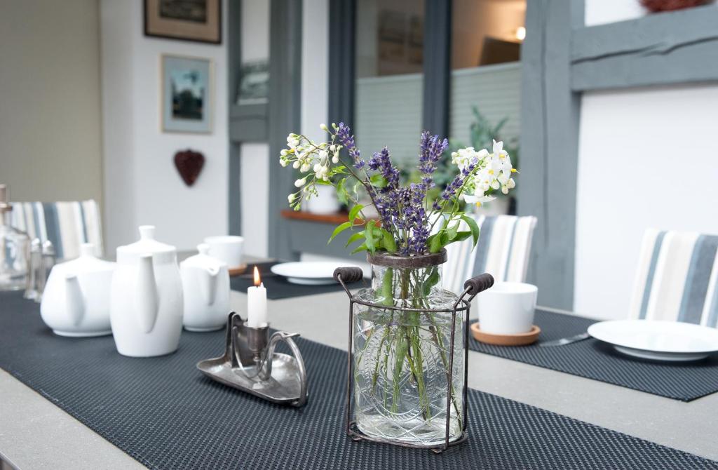 a table with a vase of flowers on a table at Ferienwohnung Sonnentau 2 in Holzminden